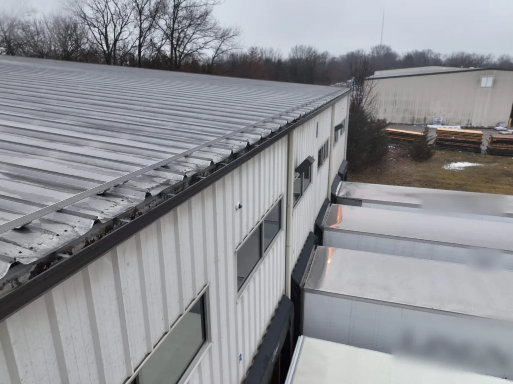Existing standing seam metal roof and gutter line on a commercial building before a retrofit