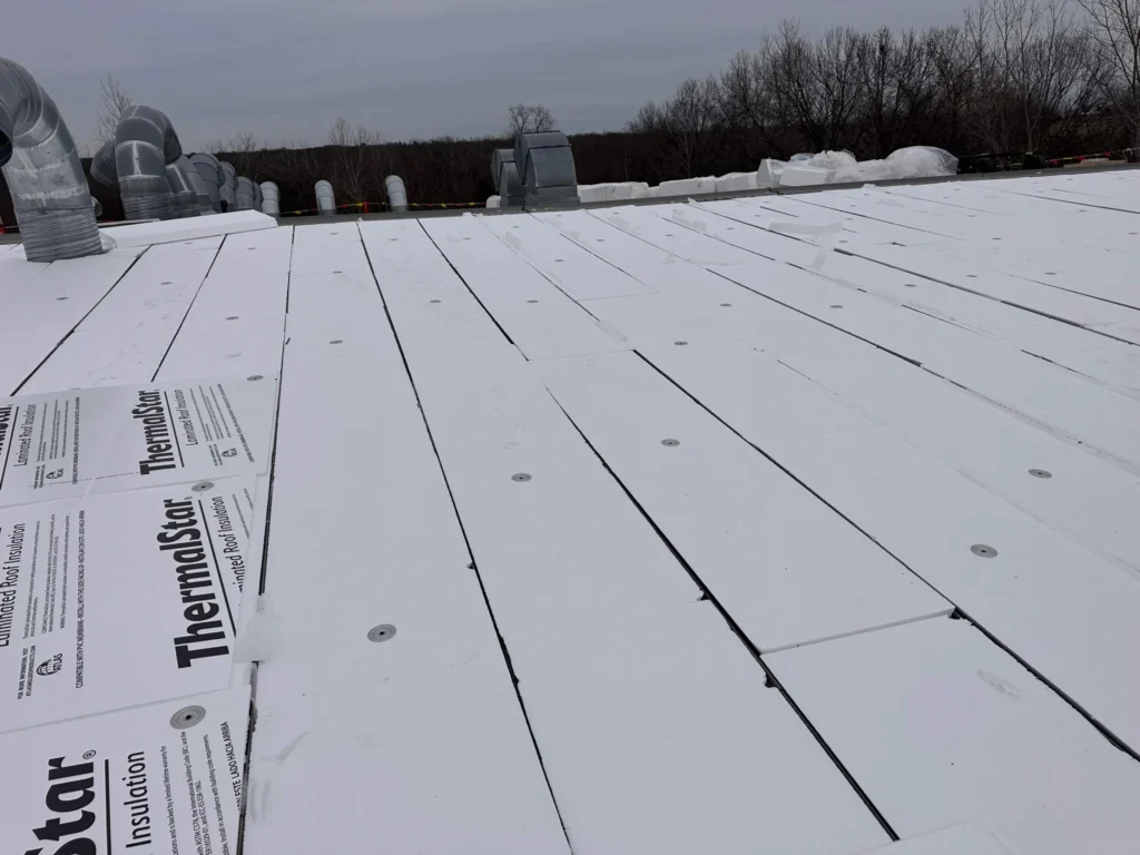 Precut insulation filling the flutes of an existing standing seam metal roof