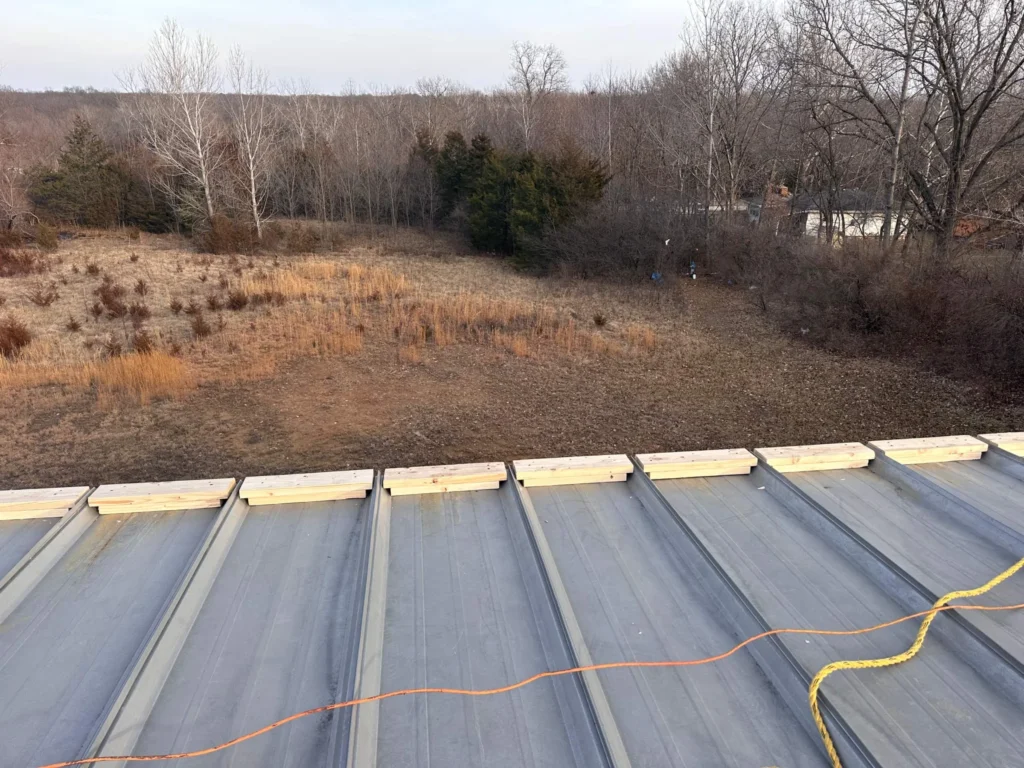 Wood blocking installed at the ends of metal roof panel flutes before a retrofit